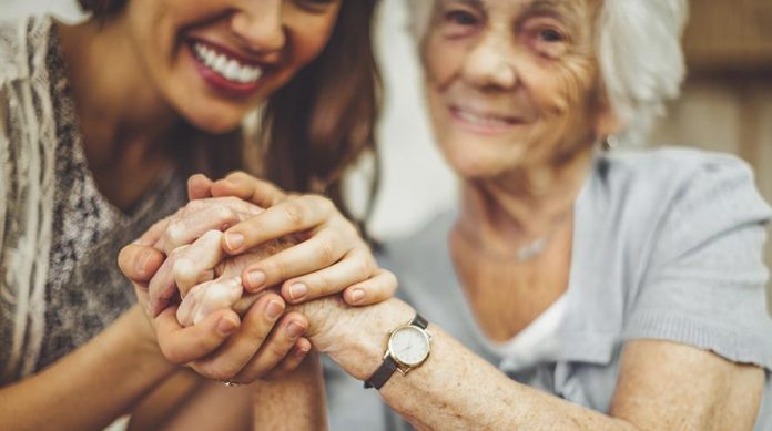 Care-worker-and-senior-woman-holding-hands (1)