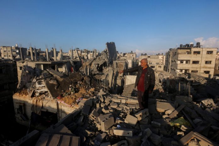 Palestinians inspect the site of Israeli strikes in Khan Younis